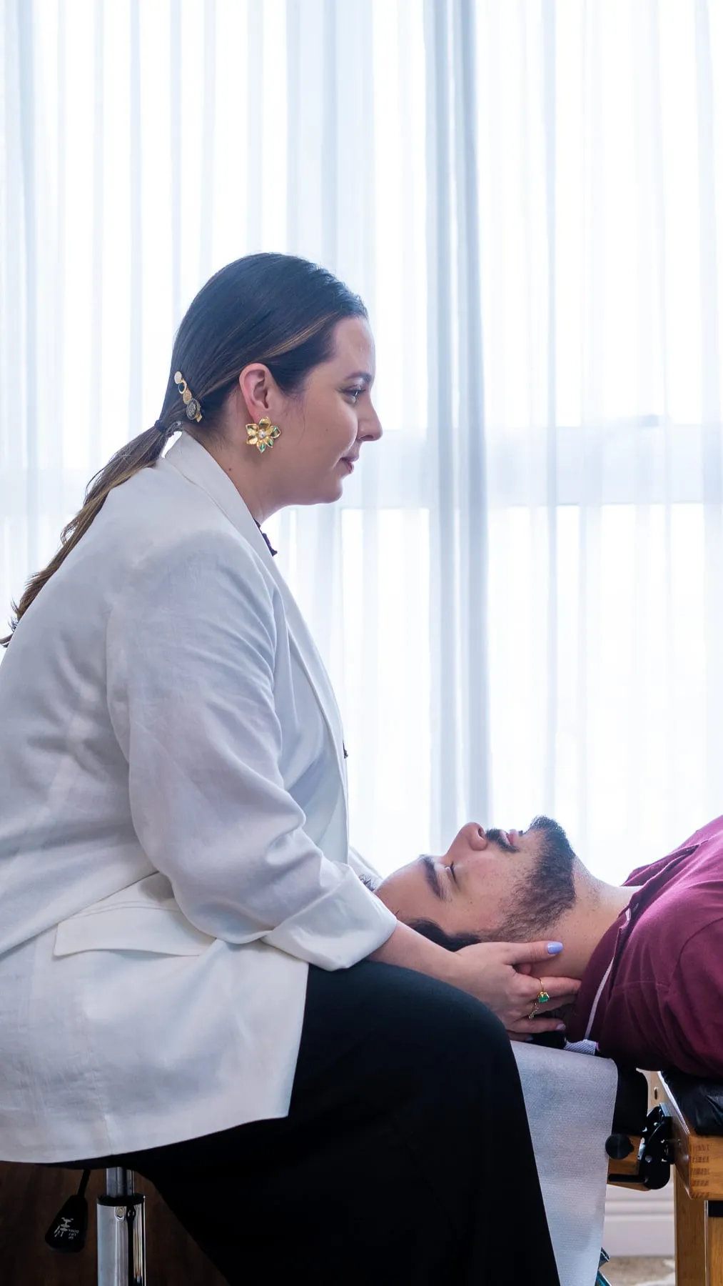 Dra. Vitória ajustando um paciente na maca do consultório